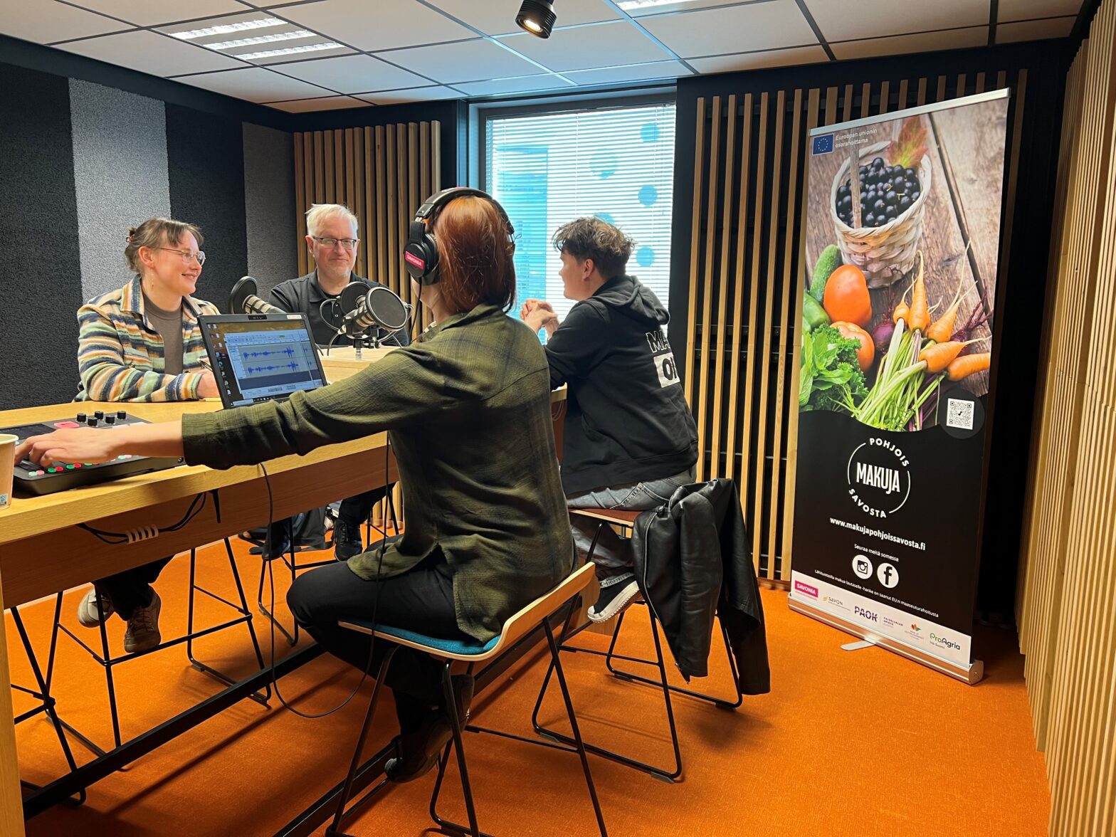 Podcast nauhoitusstudiossa 4 henkilöätyöskentelevät